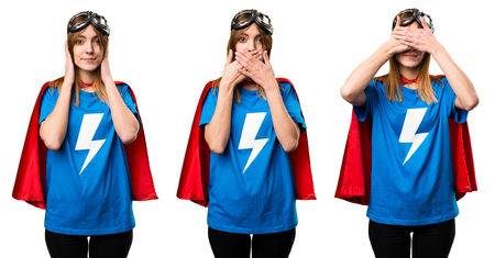 Pretty superhero girl covering her mouth, ears and eyesの写真素材