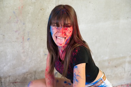 Beautiful young girl with color holi taking out her tongue