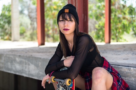 Beautiful young girl in an abandoned building with a skateの写真素材