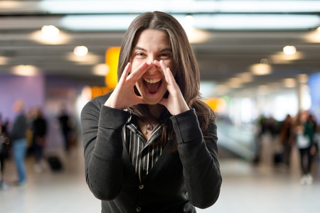 Adult girl shouting over isolated white background の写真素材