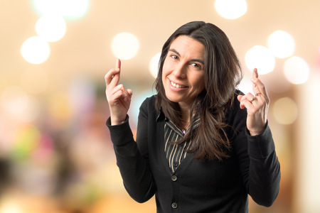Adult girl crossing his fingers over white background の写真素材