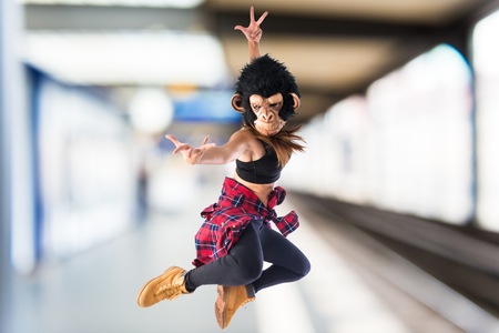 Woman with monkey mask jumping in hip hop styleの写真素材
