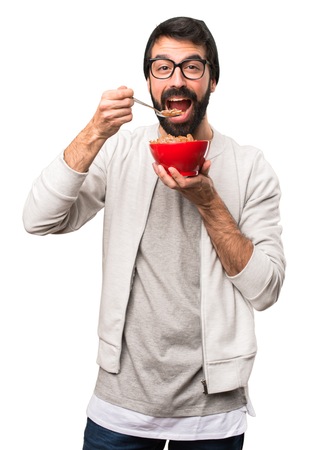 Happy Hipster man holding a bowl of cereals on white backgroundの写真素材