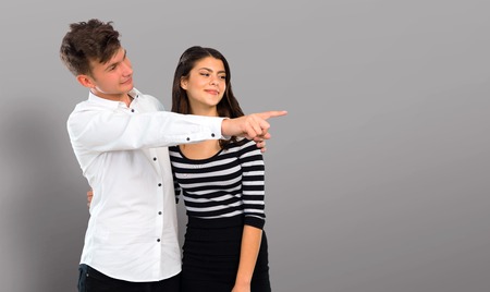 Young couple pointing finger to the side and presenting a productの写真素材