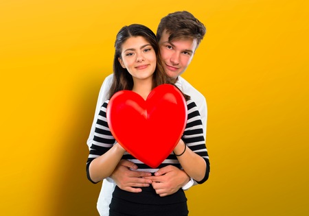 Young teenager couple holding a heart toy