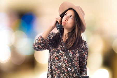 Young woman talking to vintage phone の写真素材
