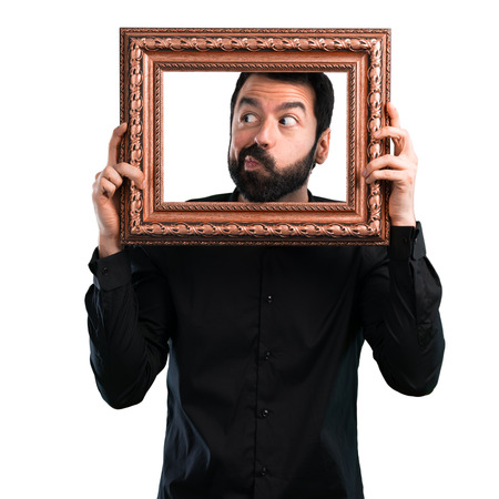 Handsome man with beard holding a framework on white background