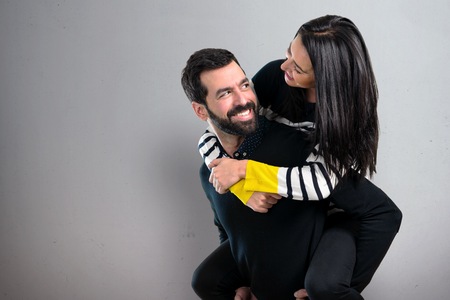 Happy young couple together on grey backgroundの写真素材