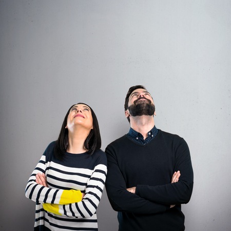 Couple looking up on grey background