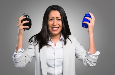 Pretty woman holding vintage clock on grey backgroundの写真素材