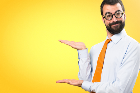 Funny man with glasses presenting something on colorful backgroundの写真素材