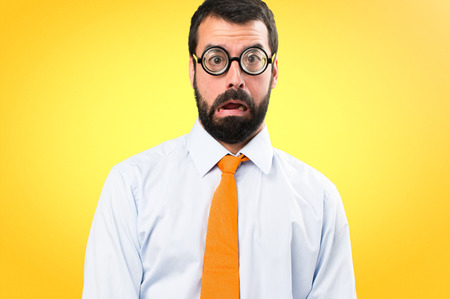 Funny man with glasses making surprise gesture on colorful backgroundの写真素材