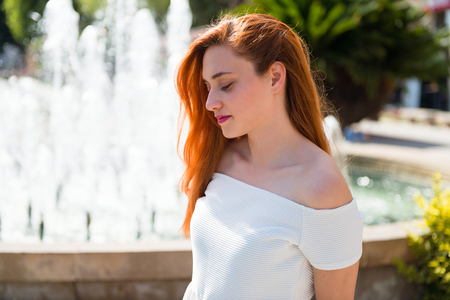 Young redhead pretty girl in a parkの写真素材