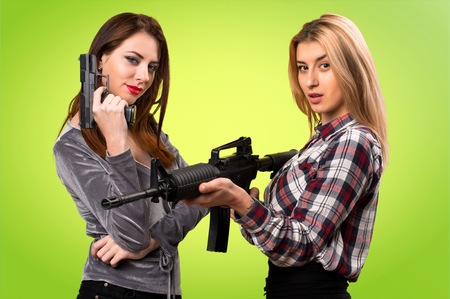 Two friends holding a rifle on colorful backgroundの写真素材