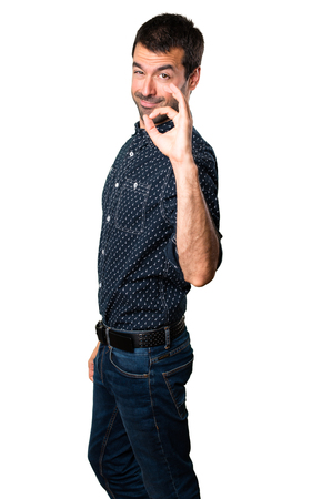 Brunette man making OK sign on isolated white backgroundの写真素材