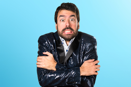 Man with jacket freezing on colorful backgroundの写真素材