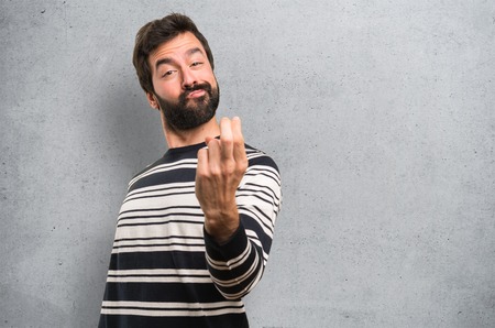Man with beard doing coming gesture on textured backgroundの写真素材