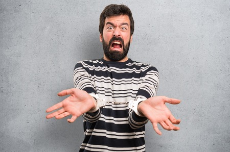 Man with beard with handcuffs on textured background