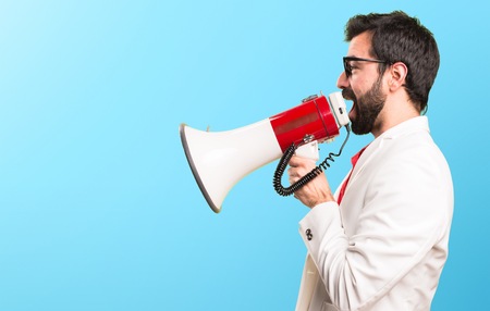 Brunette man with glasses holding a megaphone on colorful background