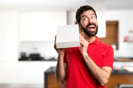 Surprised Handsome man holding a box inside houseの写真素材