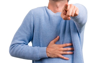 Handsome man pointing with finger at someone and laughing a lotの写真素材