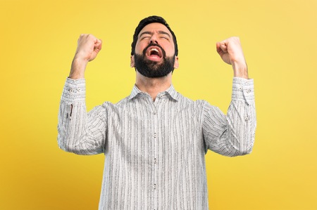 Handsome man with beard celebrating a victoryの写真素材