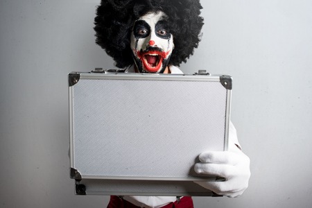 Killer clown holding a briefcase on textured backgroundの写真素材