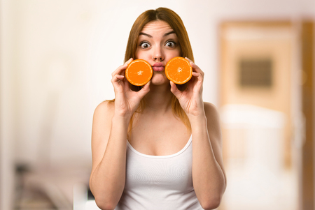 Crazy Beautiful young girl holding an orange juice on unfocused backgroundの写真素材