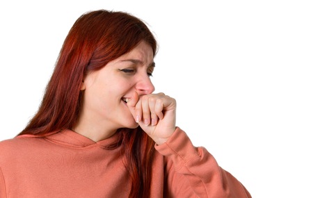 Young redhead girl with pink sweatshirt is suffering with cough and feeling bad on isolated white...