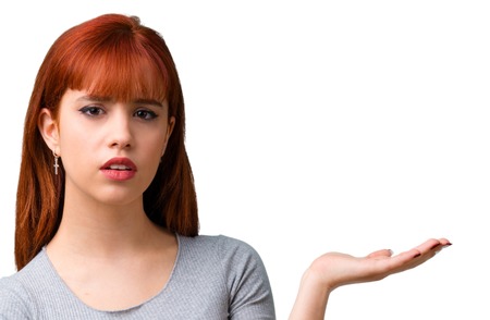 Young redhead girl unhappy and frustrated with something. Negative facial expressionの写真素材