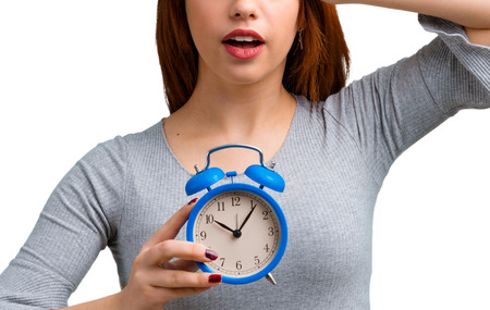 Young redhead girl holding vintage alarm clock