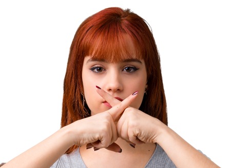 Young redhead girl showing a sign of closing mouth and silence gesture