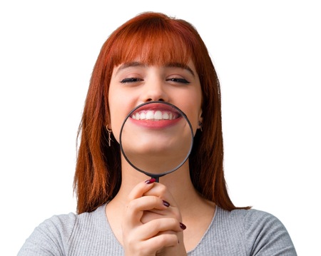 Young redhead girl holding a magnifying glassの写真素材