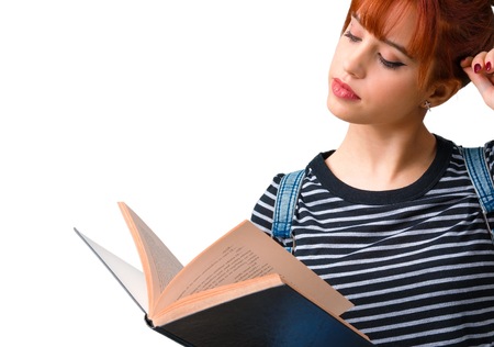 Young student redhead girl reading a book and thinking