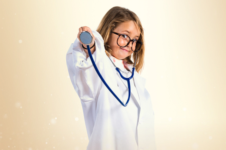 Little girl playing to be a doctor and holding a otoscopeの写真素材