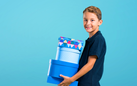 Little kid holding a gifts on color baackgroundの写真素材