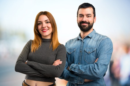 Man and woman with their arms crossed on unfocused backgroundの写真素材