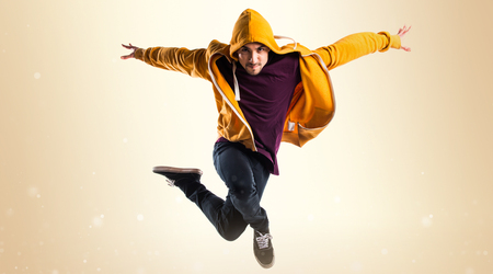 Man dancing street dance on ocher backgroundの写真素材
