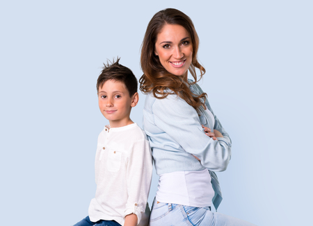 Mother and daughter keeping arms crossed on blue backgroundの写真素材