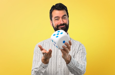 Handsome man with beard holding a dice