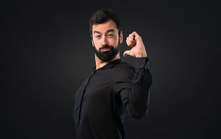 Handsome man with beard proud of himself on black backgroundの写真素材