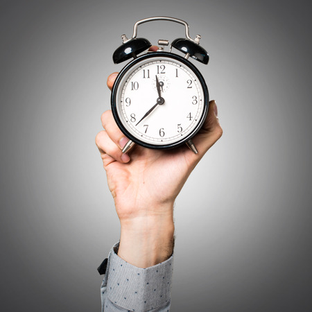 Hand of man holding vintage clockの写真素材