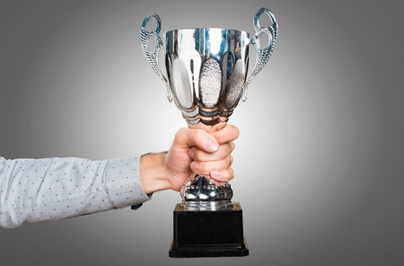 Hand of man holding holding a trophyの写真素材