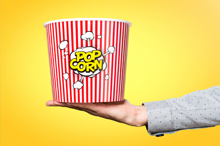 Hand of man holding popcorn boxの写真素材