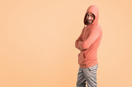 Man in a pink sweatshirt on ocher backgroundの写真素材