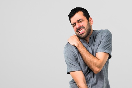 Handsome man with shoulder pain on grey backgroundの写真素材