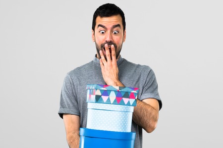 Handsome man holding boxes on grey backgroundの写真素材