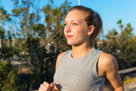 Young sport woman doing exercise and running in the park