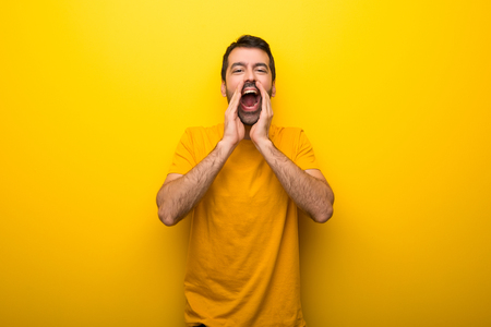 Man on isolated vibrant yellow color shouting and announcing somethingの写真素材
