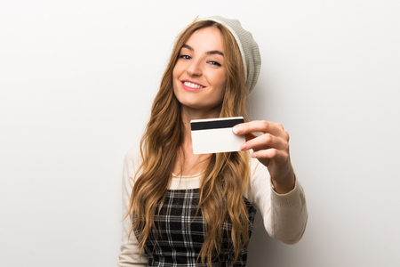 Fashionably woman wearing hat holding a credit cardの写真素材